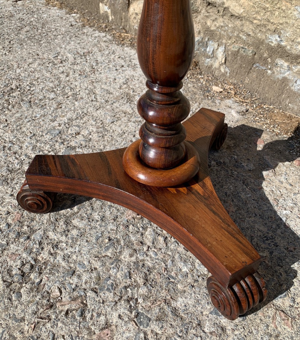 A Regency rosewood pole screen with a circular needlepoint panel on a turned column and triform base. View IX