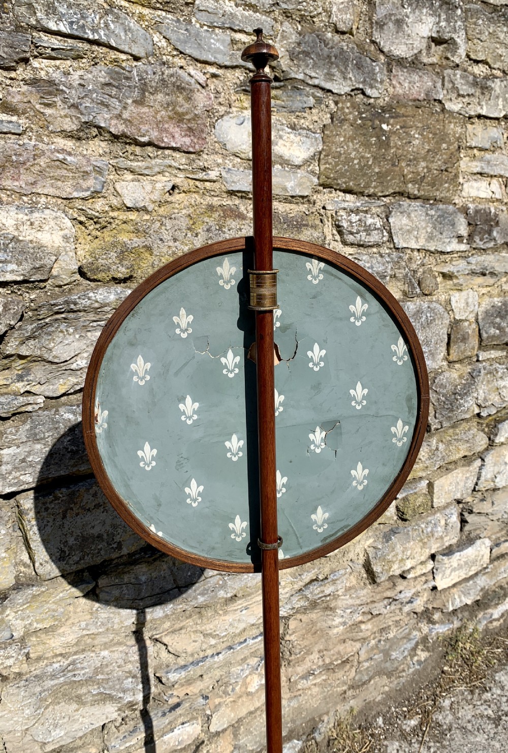 A Regency rosewood pole screen with a circular needlepoint panel on a turned column and triform base. View XIII
