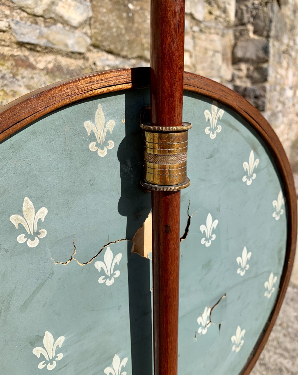 A Regency rosewood pole screen with a circular needlepoint panel on a turned column and triform base. View XIV