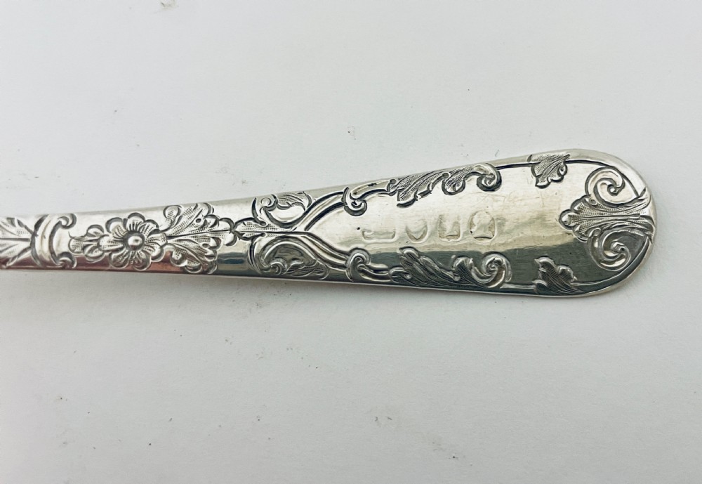 A Georgian sterling silver sugar sifter spoon featuring a hand-pierced foliate bowl design and an engraved floral handle. View XI