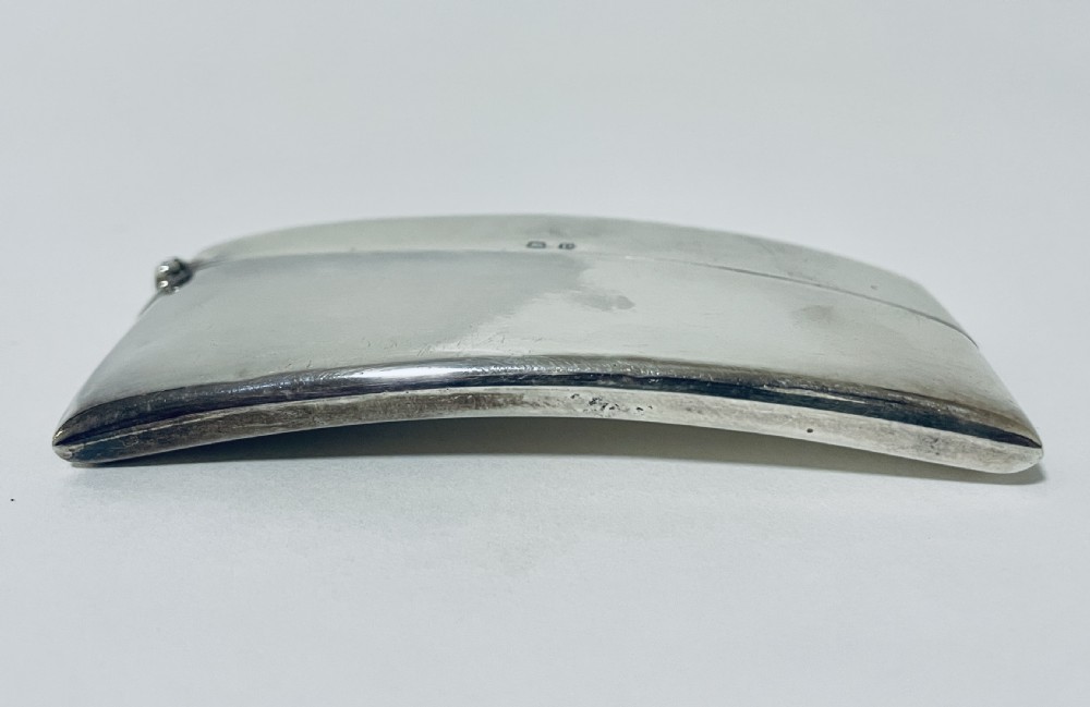 A polished sterling silver rectangular calling card case featuring a gentle curve and visible British hallmarks near the upper rim. View XI