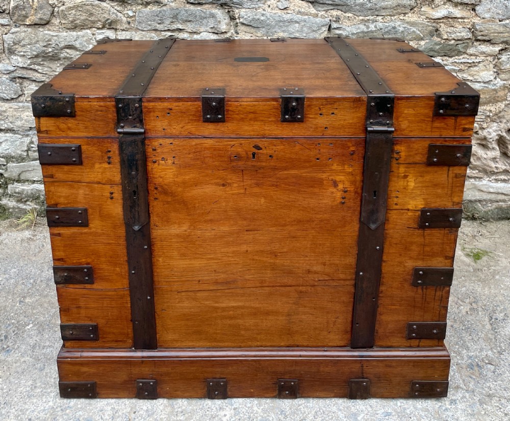 A large Victorian warm brown oak silver chest featuring dark iron straps, corner brackets, and a central keyhole.