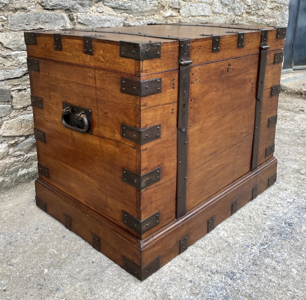 A large Victorian warm brown oak silver chest featuring dark iron straps, corner brackets, and a central keyhole. View V