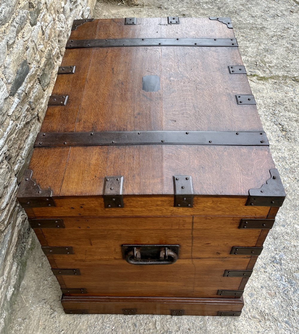 A large Victorian warm brown oak silver chest featuring dark iron straps, corner brackets, and a central keyhole. View VI
