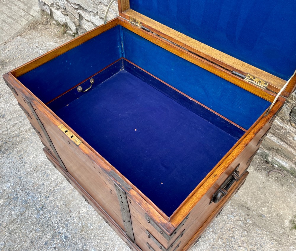 A large Victorian warm brown oak silver chest featuring dark iron straps, corner brackets, and a central keyhole. View XXX