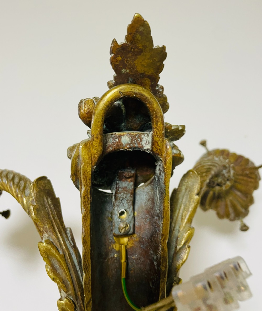 A Victorian twin-arm gilt brass wall sconce featuring reeded details, acanthus leaf motifs, and frosted frilled glass shades with etched floral patterns. View XVII