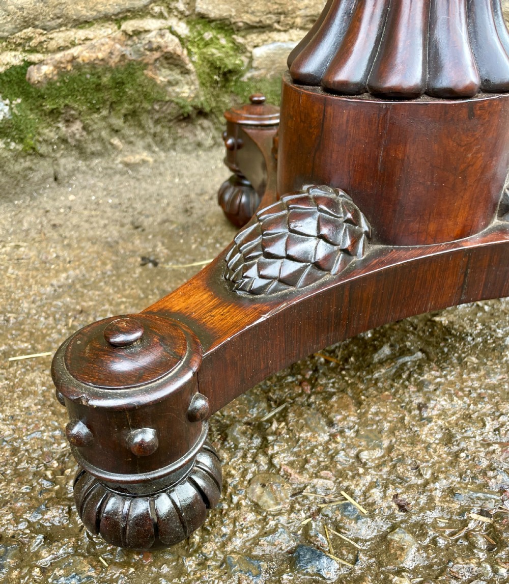 A Regency rosewood pole screen featuring a carved tripod base, adjustable brass rod, and a framed needlepoint panel with a floral wreath. View III