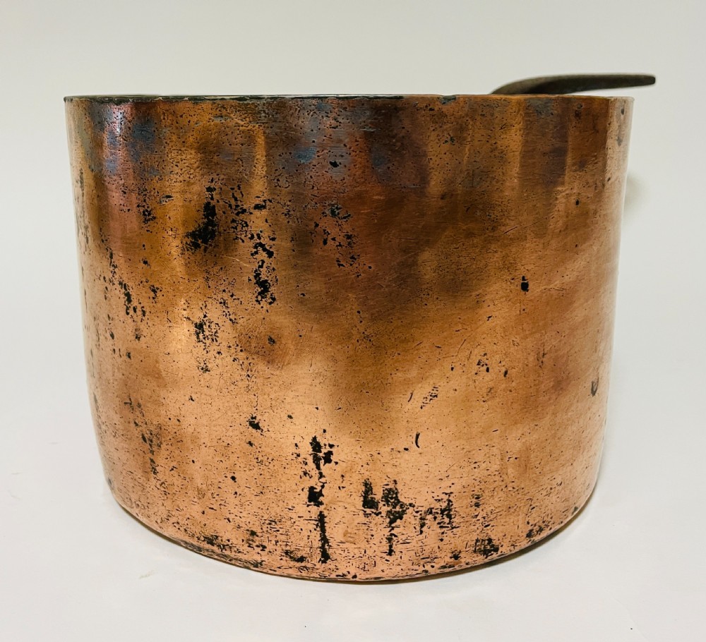 A large Victorian copper saucepan with a flat copper lid and a long dark cast iron handle. View V