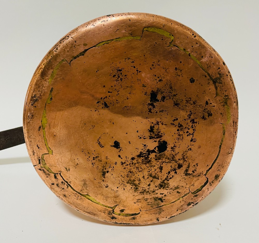 A large Victorian copper saucepan with a flat copper lid and a long dark cast iron handle. View VII