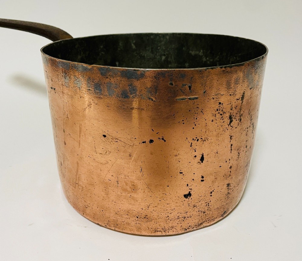 A large Victorian copper saucepan with a flat copper lid and a long dark cast iron handle. View IX