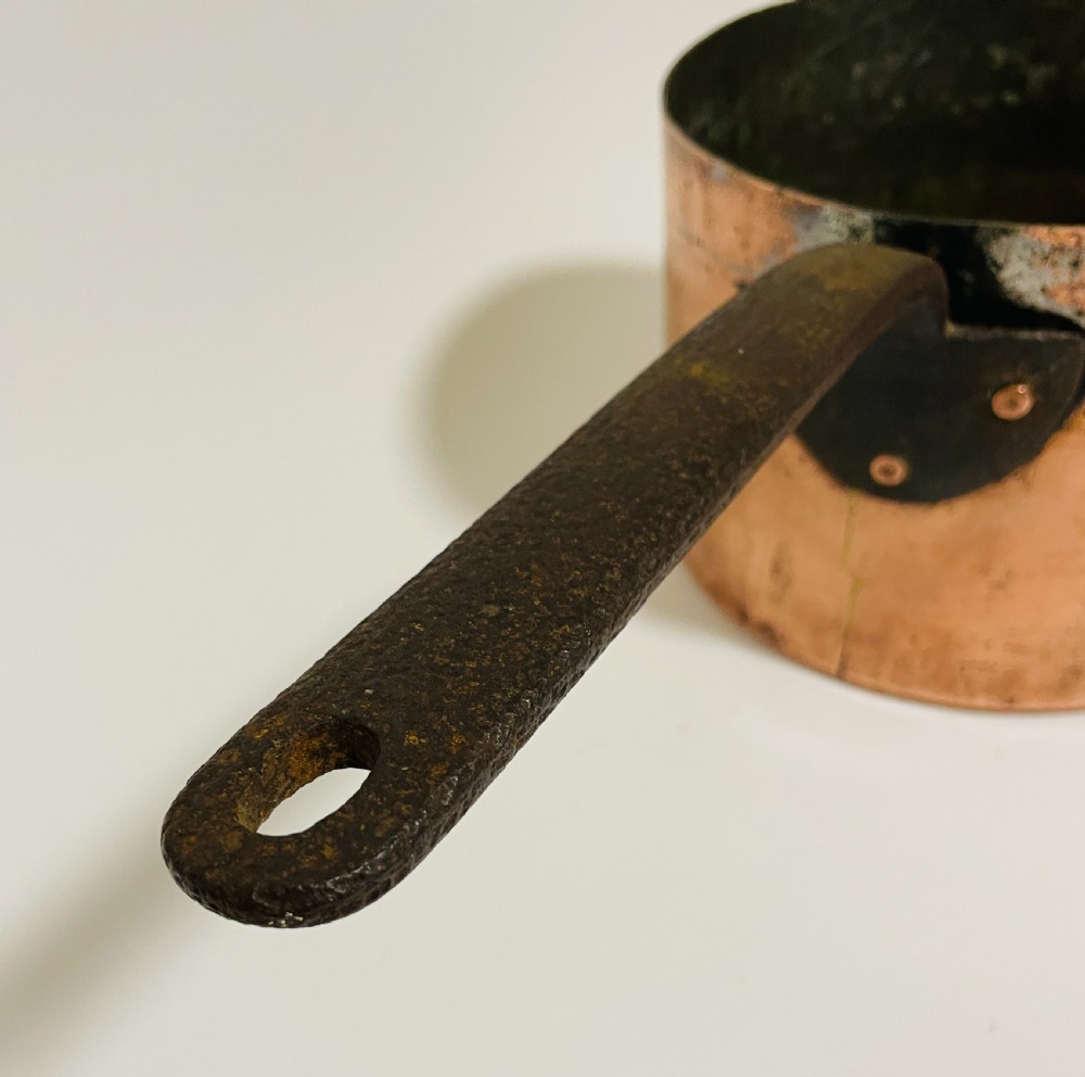 A large Victorian copper saucepan with a flat copper lid and a long dark cast iron handle. View X
