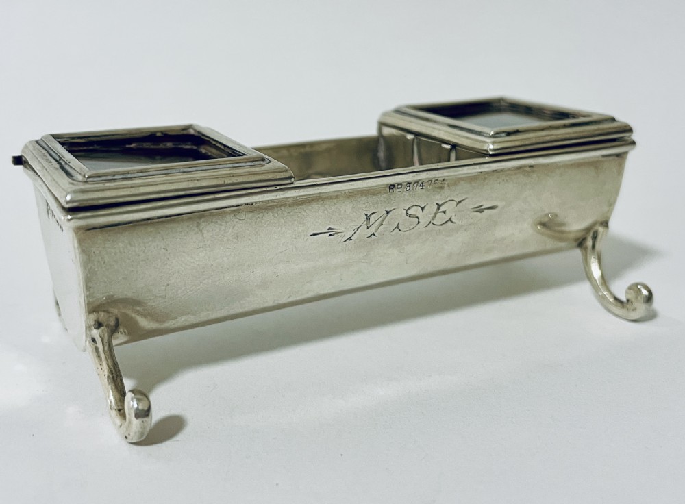 A rectangular Victorian silver double stamp trough with an engraved monogram, raised on four scrolled legs with two glass-topped compartments. View VIII