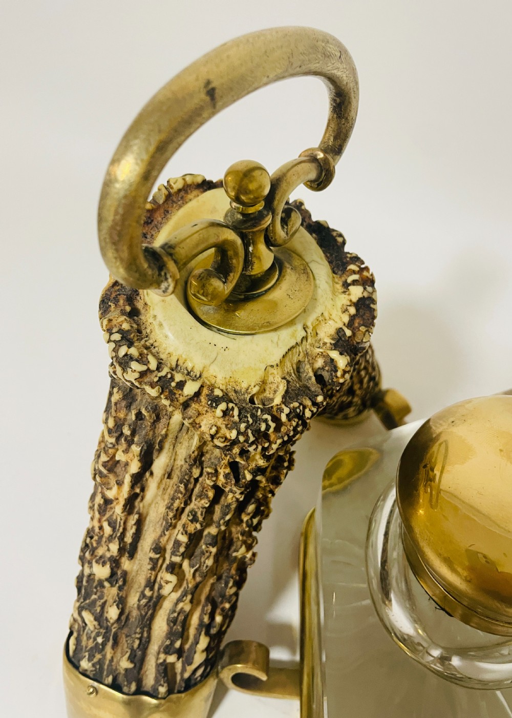 A Victorian desk set featuring a cut-glass inkwell in a brass frame, a brass letter opener with an antler handle, two small antler candlesticks, and a central brass-handled antler object. View VI