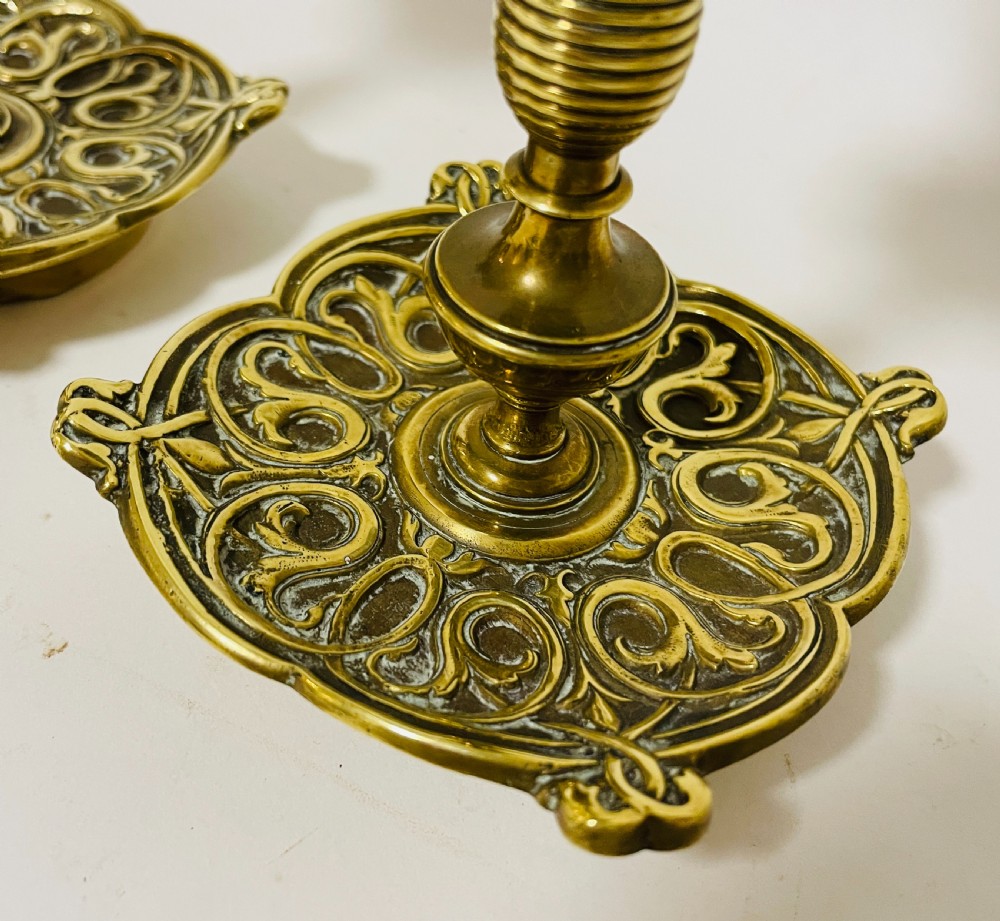 An ornate antique brass desk set featuring a lidded inkwell on a scrolled stand, a matching pen tray, and two turned brass candlesticks. View III