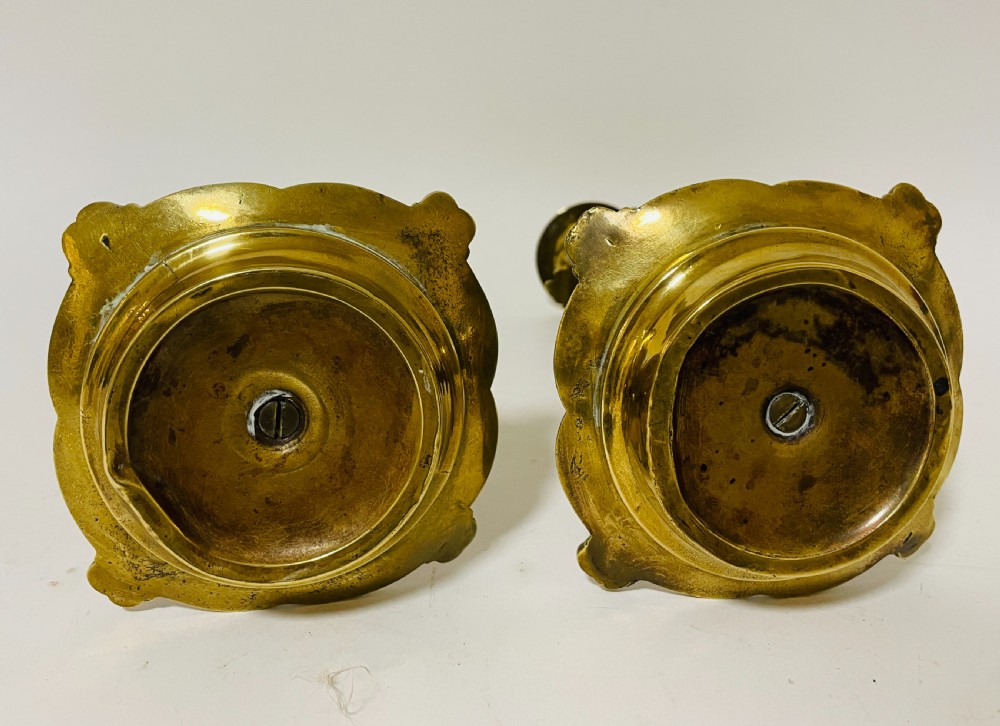 An ornate antique brass desk set featuring a lidded inkwell on a scrolled stand, a matching pen tray, and two turned brass candlesticks. View VII