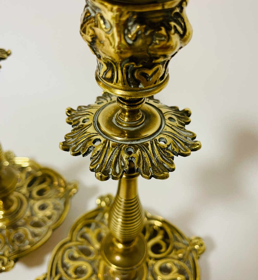 An ornate antique brass desk set featuring a lidded inkwell on a scrolled stand, a matching pen tray, and two turned brass candlesticks. View VIII