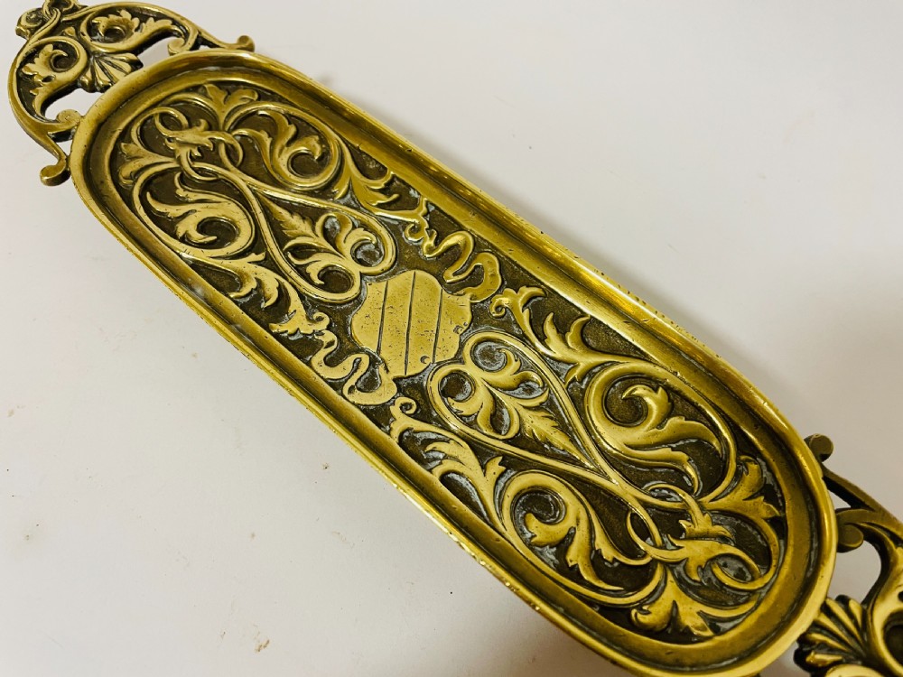 An ornate antique brass desk set featuring a lidded inkwell on a scrolled stand, a matching pen tray, and two turned brass candlesticks. View XVIII