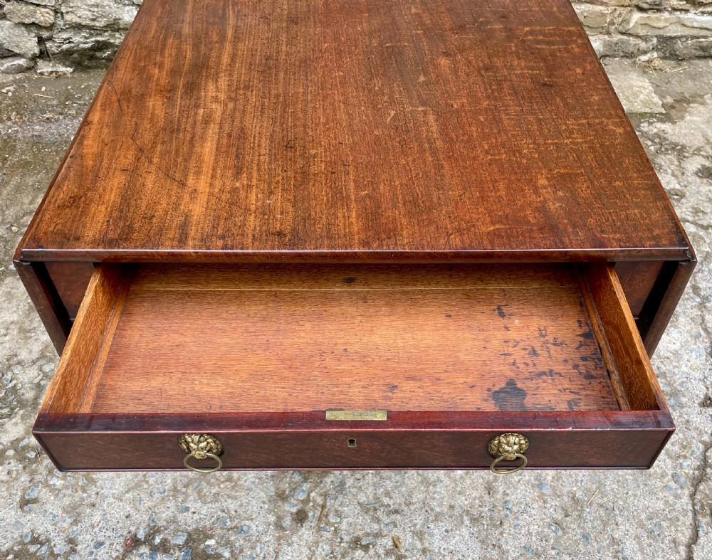 A Regency mahogany drop leaf pedestal table featuring reeded splayed legs, brass paw castors, and a drawer with lion mask handles. View II