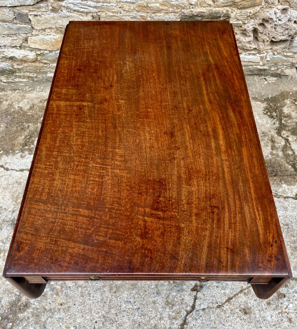 A Regency mahogany drop leaf pedestal table featuring reeded splayed legs, brass paw castors, and a drawer with lion mask handles. View XIX