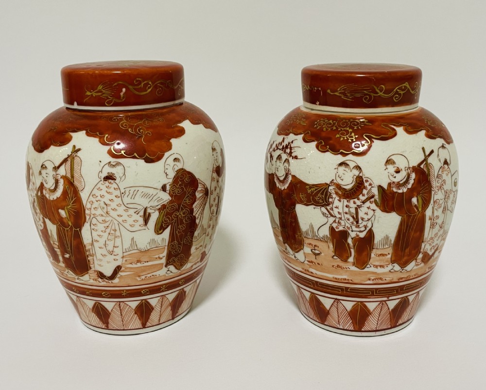 A pair of Japanese Kutani porcelain ginger jars decorated with iron-red hand-painted figures of children playing beneath decorative cloud and leaf borders. View II