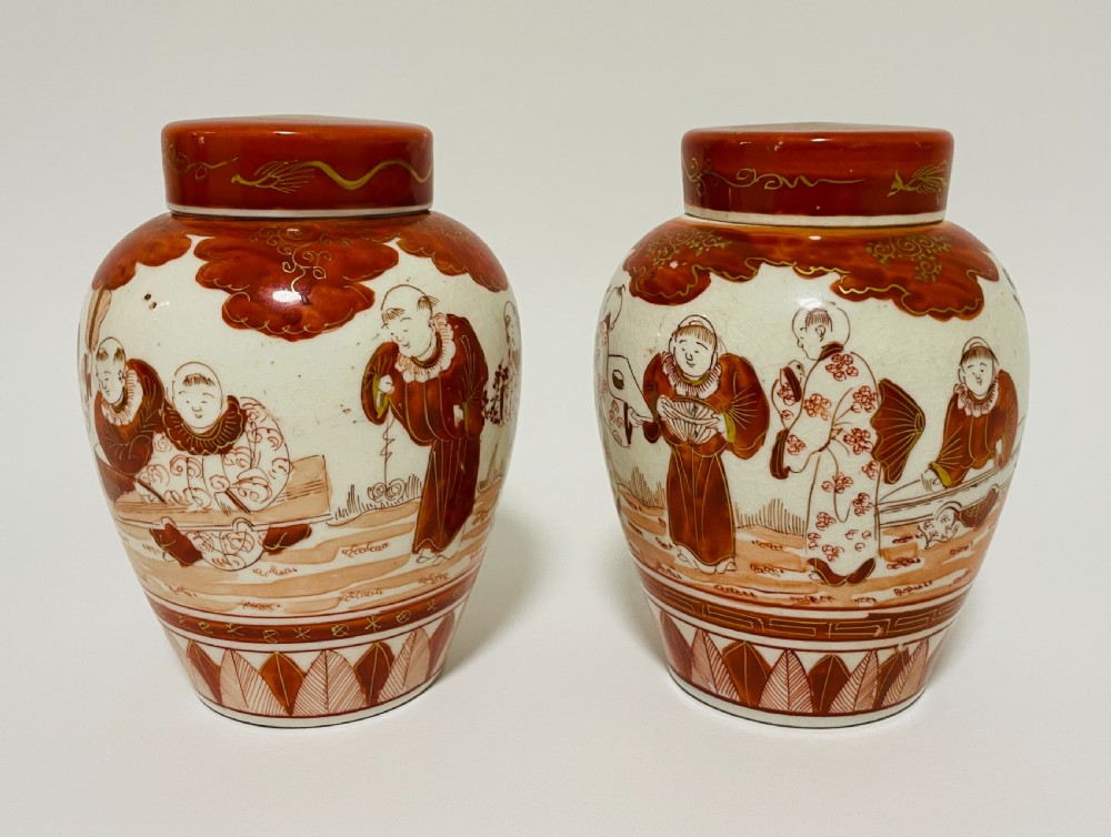 A pair of Japanese Kutani porcelain ginger jars decorated with iron-red hand-painted figures of children playing beneath decorative cloud and leaf borders. View VII