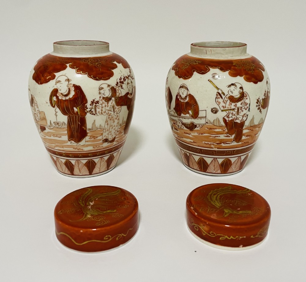 A pair of Japanese Kutani porcelain ginger jars decorated with iron-red hand-painted figures of children playing beneath decorative cloud and leaf borders. View IX