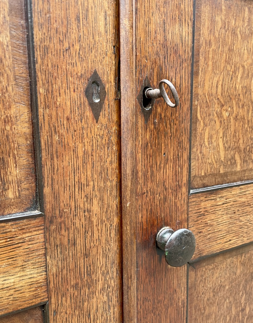 A floor-standing Georgian oak corner cupboard featuring double panelled doors and a moulded top cornice. View XI
