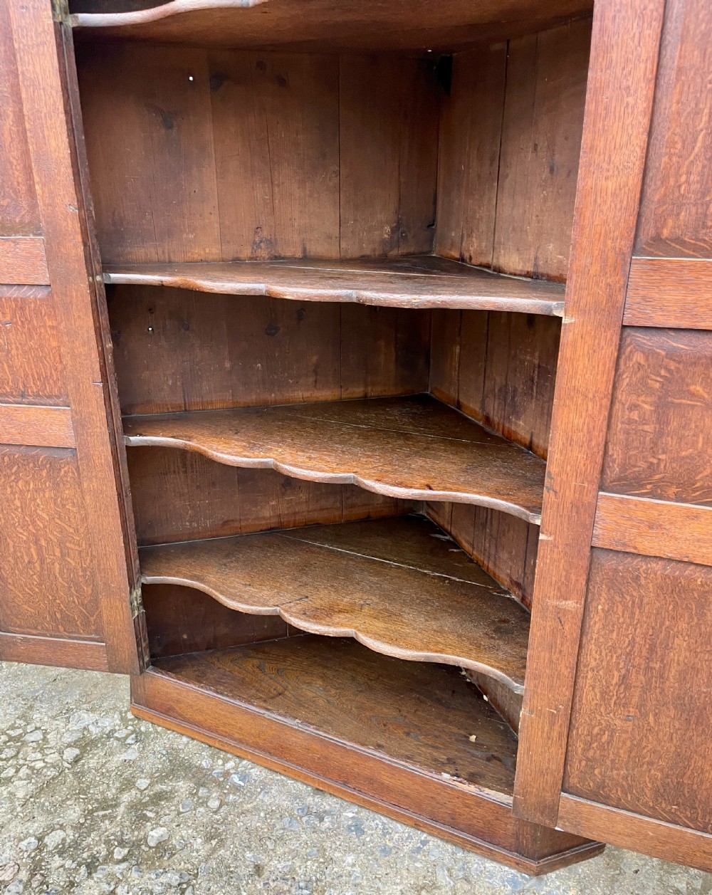 A floor-standing Georgian oak corner cupboard featuring double panelled doors and a moulded top cornice. View XIV