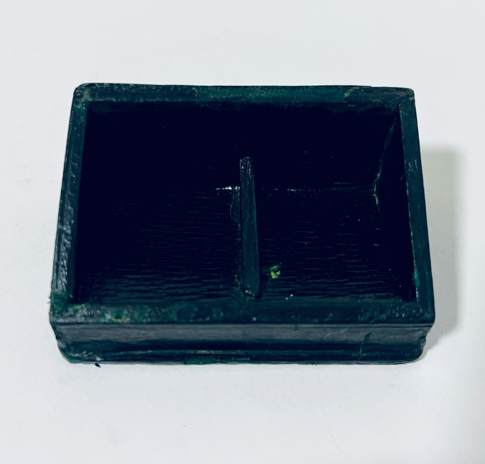An Edwardian sterling silver double stamp box featuring two glass apertures displaying green half-penny and red one-penny stamps set on a dark leather-covered base. View XIII