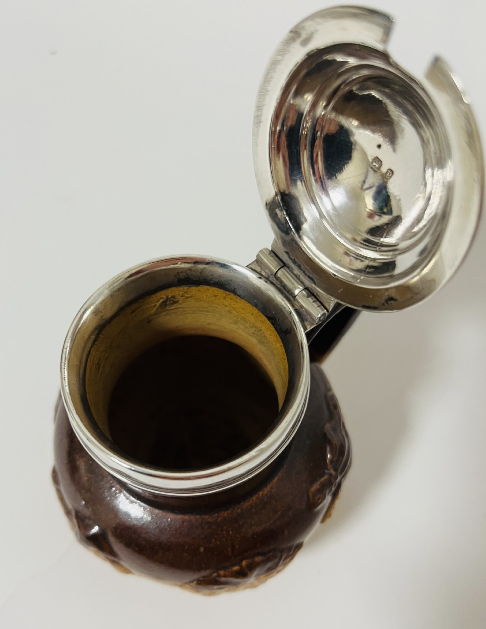 A Victorian two-tone brown stoneware mustard pot featuring relief-moulded rural scenes, a side handle, and a polished silver hinged lid. View XII