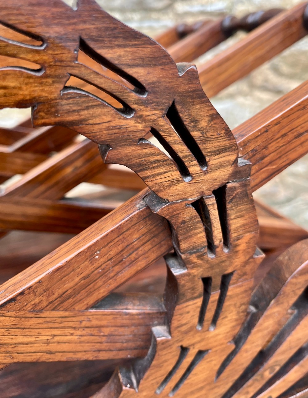 A Regency rosewood music canterbury featuring carved wreath motif side panels, slatted partitions, a single base drawer, and turned legs on brass castors. View XII