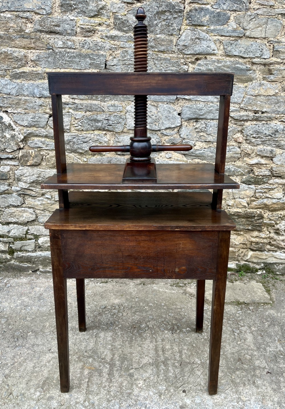 An antique oak and elm book press table featuring a central turned wooden screw mechanism above a single drawer with two round knobs. View XX