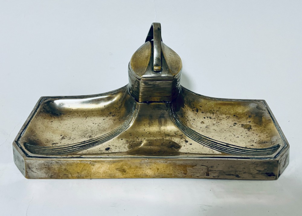 An antique Art Nouveau silver-plated desk stand featuring a central hinged inkwell flanked by two pen trays.