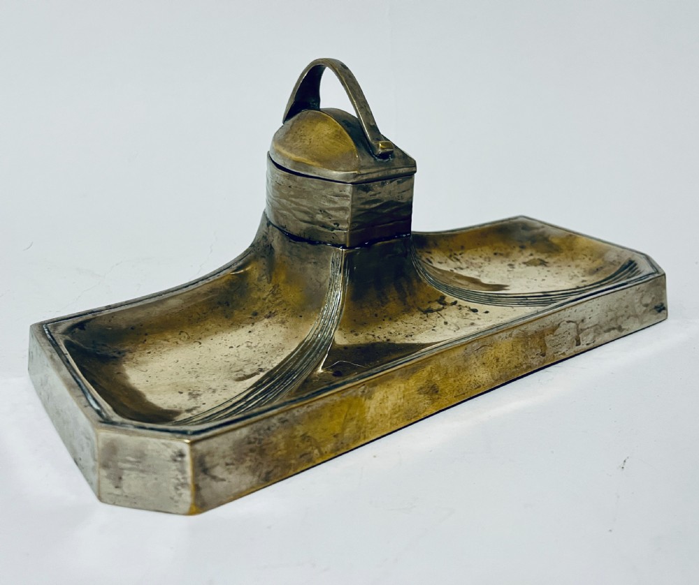 An antique Art Nouveau silver-plated desk stand featuring a central hinged inkwell flanked by two pen trays. View IV