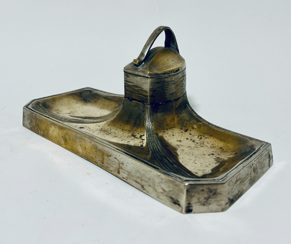 An antique Art Nouveau silver-plated desk stand featuring a central hinged inkwell flanked by two pen trays. View V