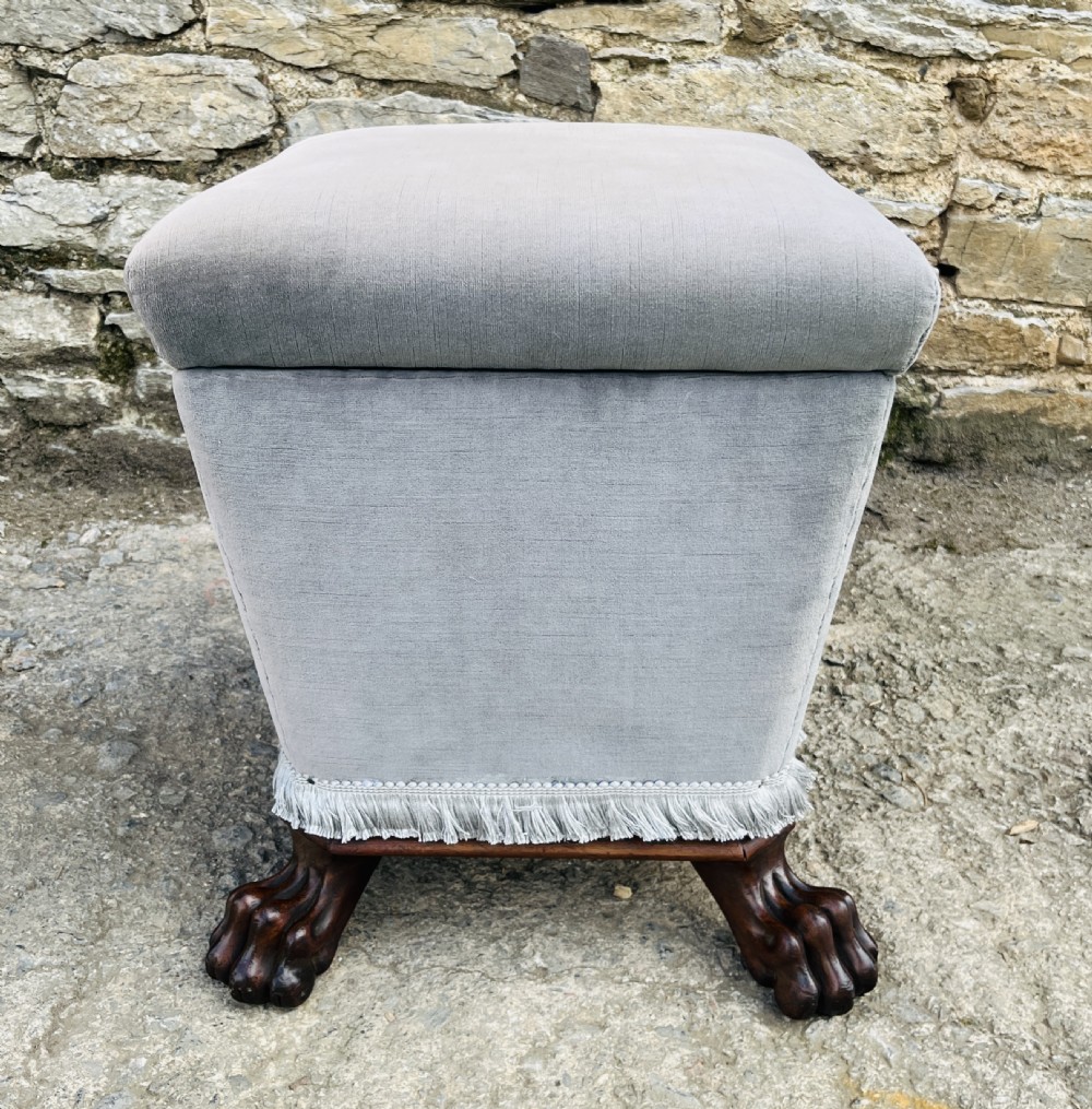 An upholstered grey velvet box ottoman featuring lower fringe trimming and dark mahogany carved lions paw feet. View XII