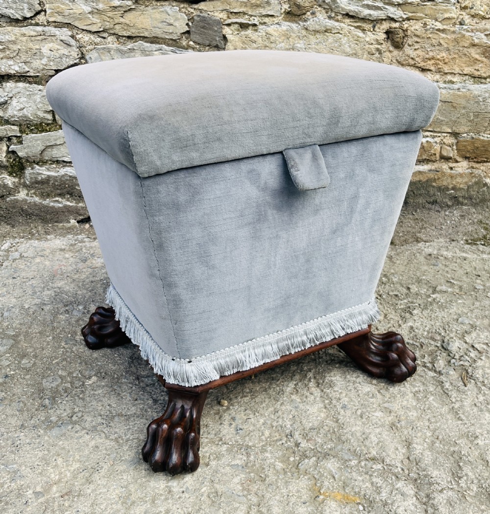 An upholstered grey velvet box ottoman featuring lower fringe trimming and dark mahogany carved lions paw feet. View XIV
