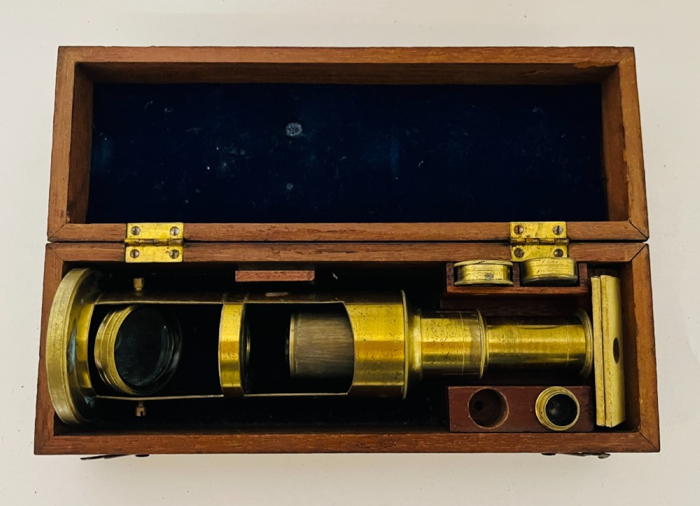 A Victorian brass drum microscope seated in its original fitted mahogany box with brass clasps. View II