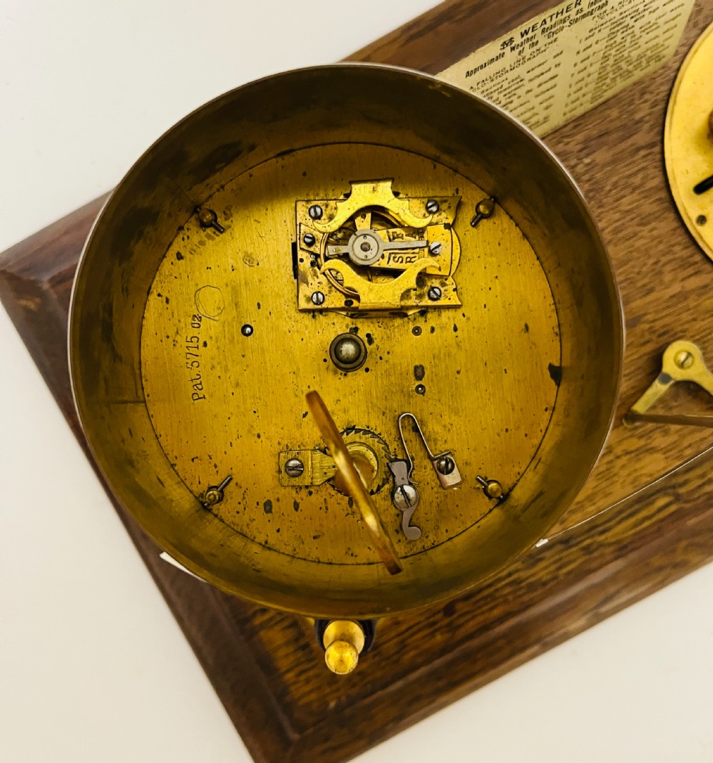 An antique barograph featuring an oak frame with glass side panels enclosing a revolving paper chart drum and polished brass mechanism. View XVII