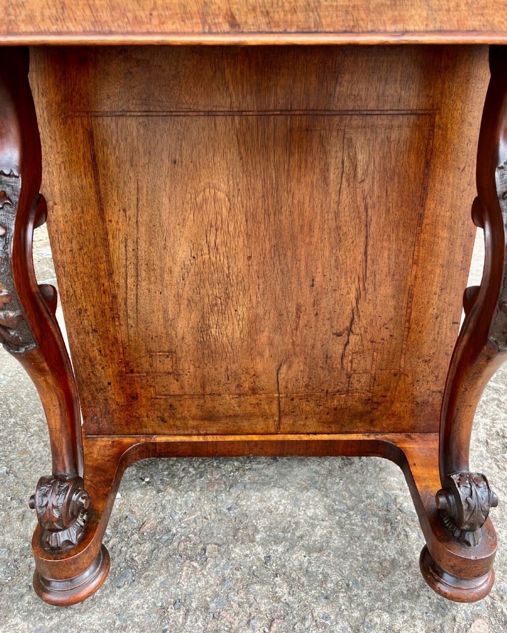 A Victorian burr walnut Davenport desk featuring a sloped writing top with a green leather insert and carved acanthus leaf front supports. View XV