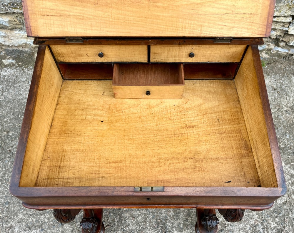 A Victorian burr walnut Davenport desk featuring a sloped writing top with a green leather insert and carved acanthus leaf front supports. View XXI