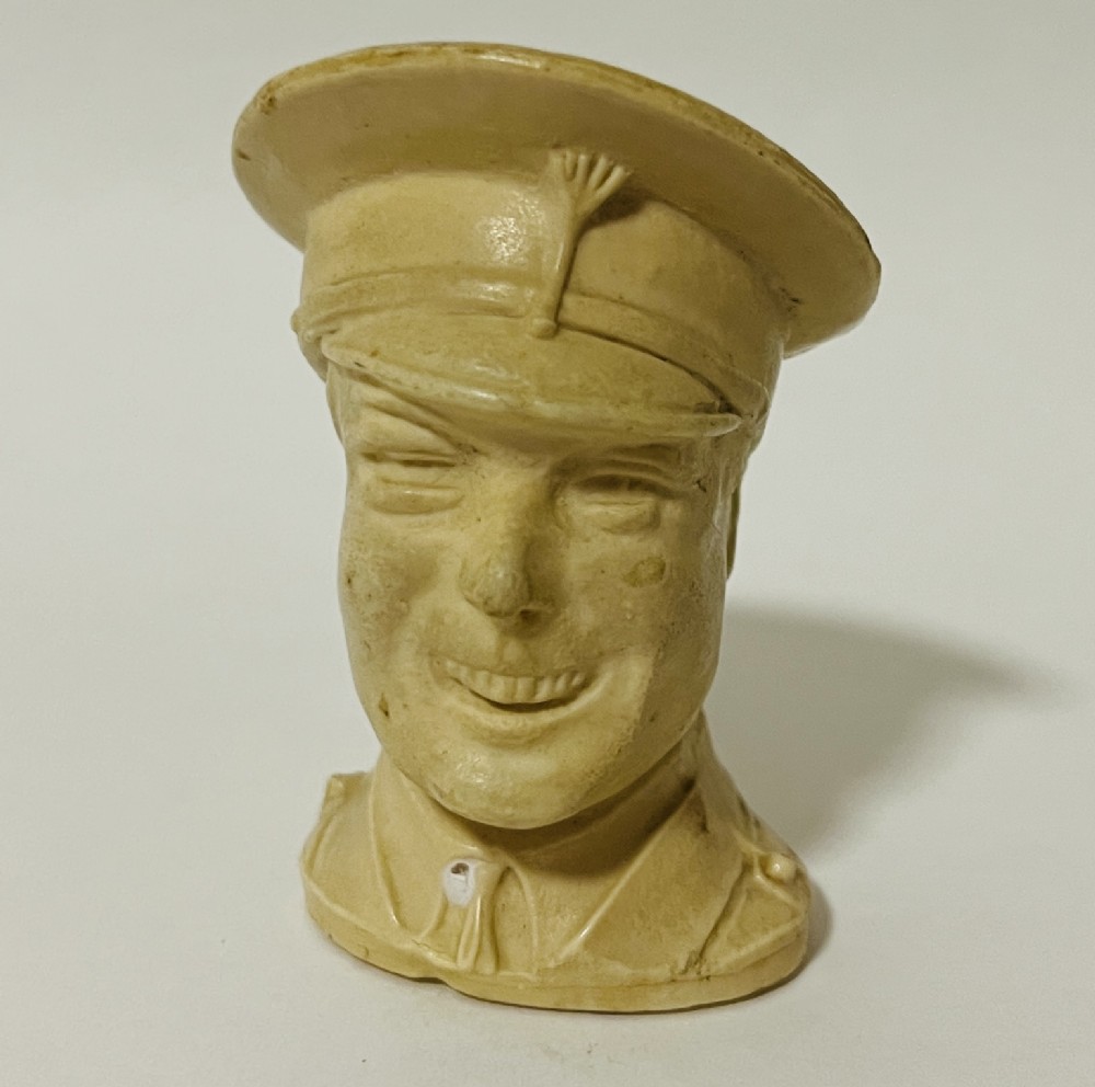 A cream-coloured moulded celluloid novelty tape measure depicting a military bust of King Edward VIII.