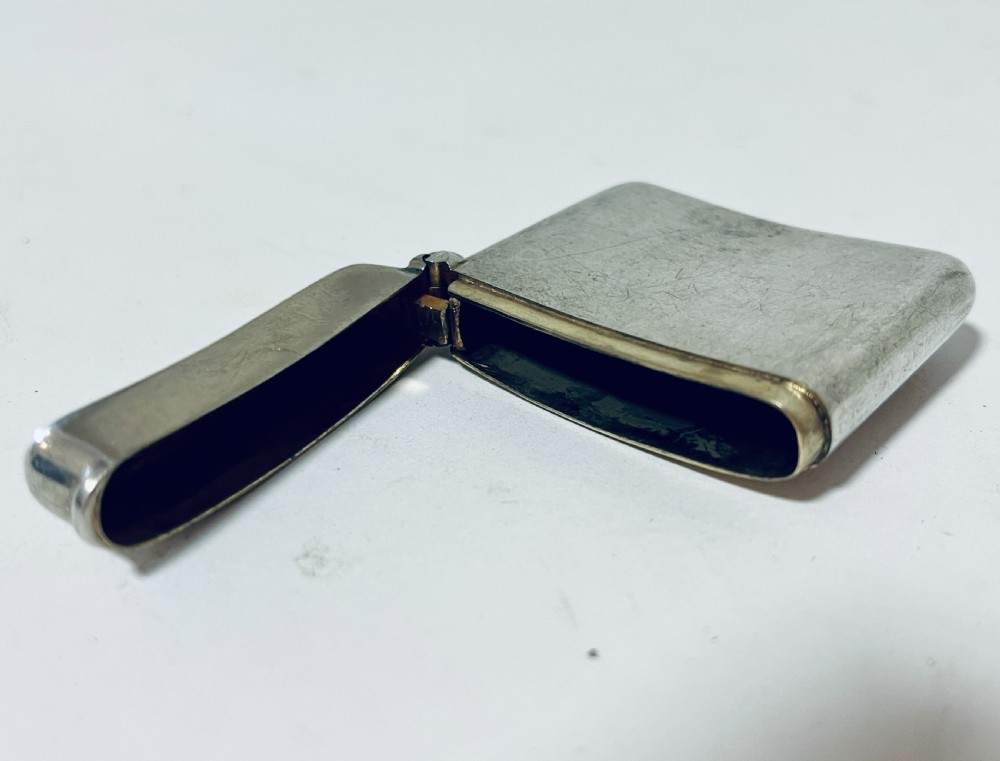 An antique plain sterling silver vesta case featuring rounded corners, a hinged lid, and a small side suspension loop. View IX
