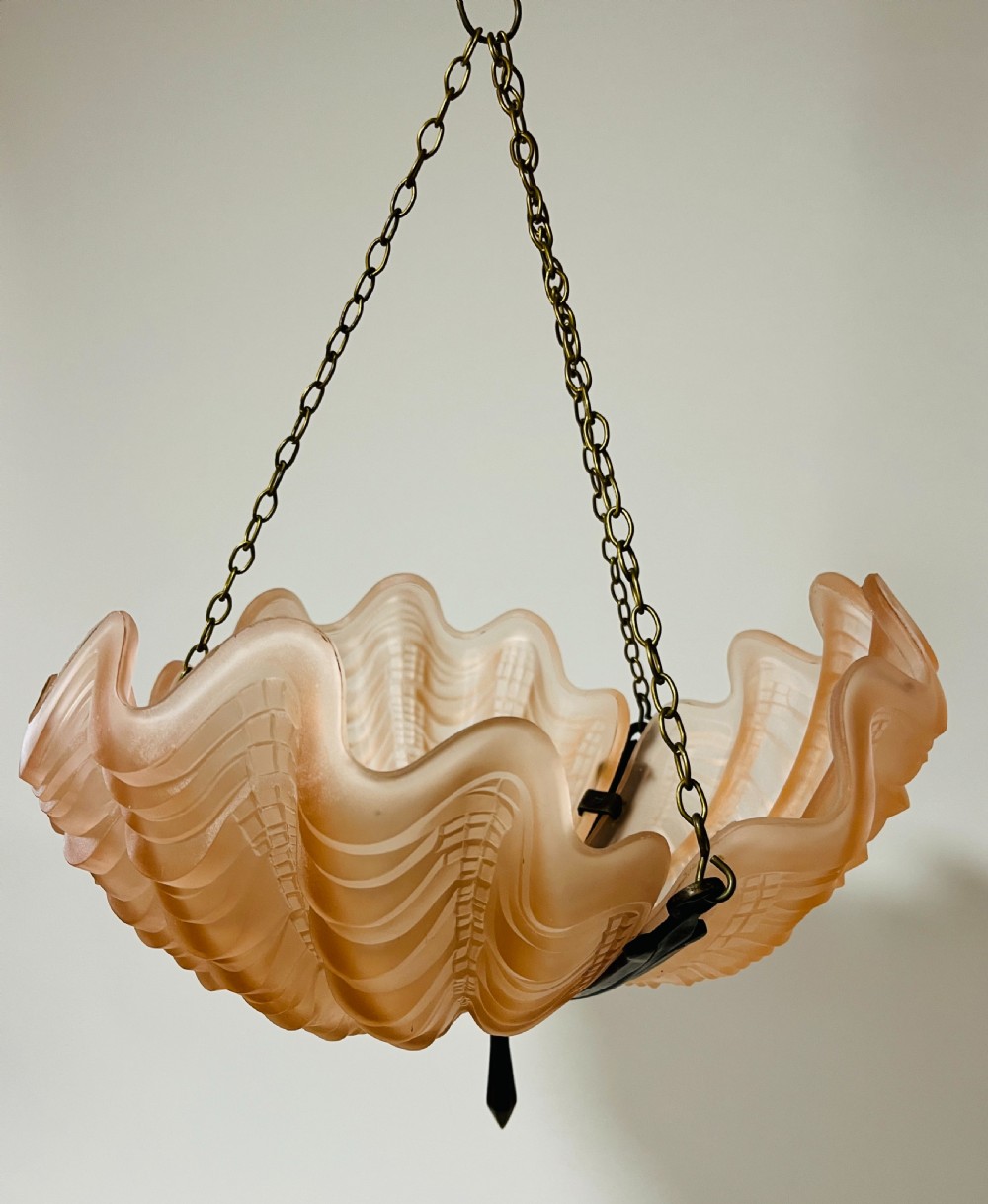 An Art Deco pink frosted glass clam shell ceiling pendant light suspended by three brass hanging chains. View III