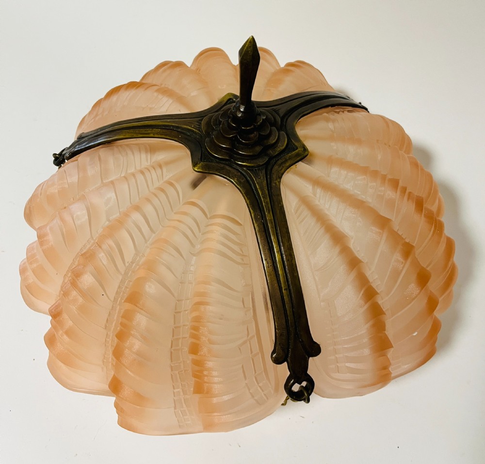 An Art Deco pink frosted glass clam shell ceiling pendant light suspended by three brass hanging chains. View IV