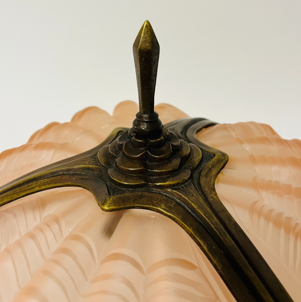 An Art Deco pink frosted glass clam shell ceiling pendant light suspended by three brass hanging chains. View VII