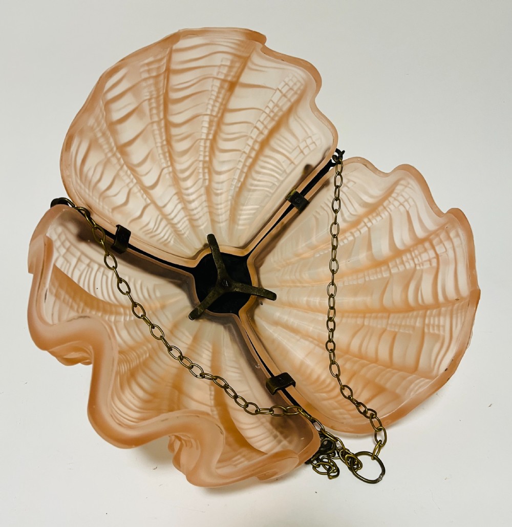 An Art Deco pink frosted glass clam shell ceiling pendant light suspended by three brass hanging chains. View IX