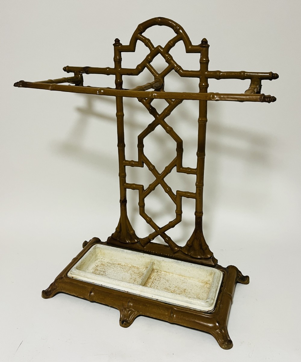 A Victorian cast iron faux bamboo umbrella stand in brown paint featuring geometric lattice backwork and a removable two-compartment drip tray. View IX