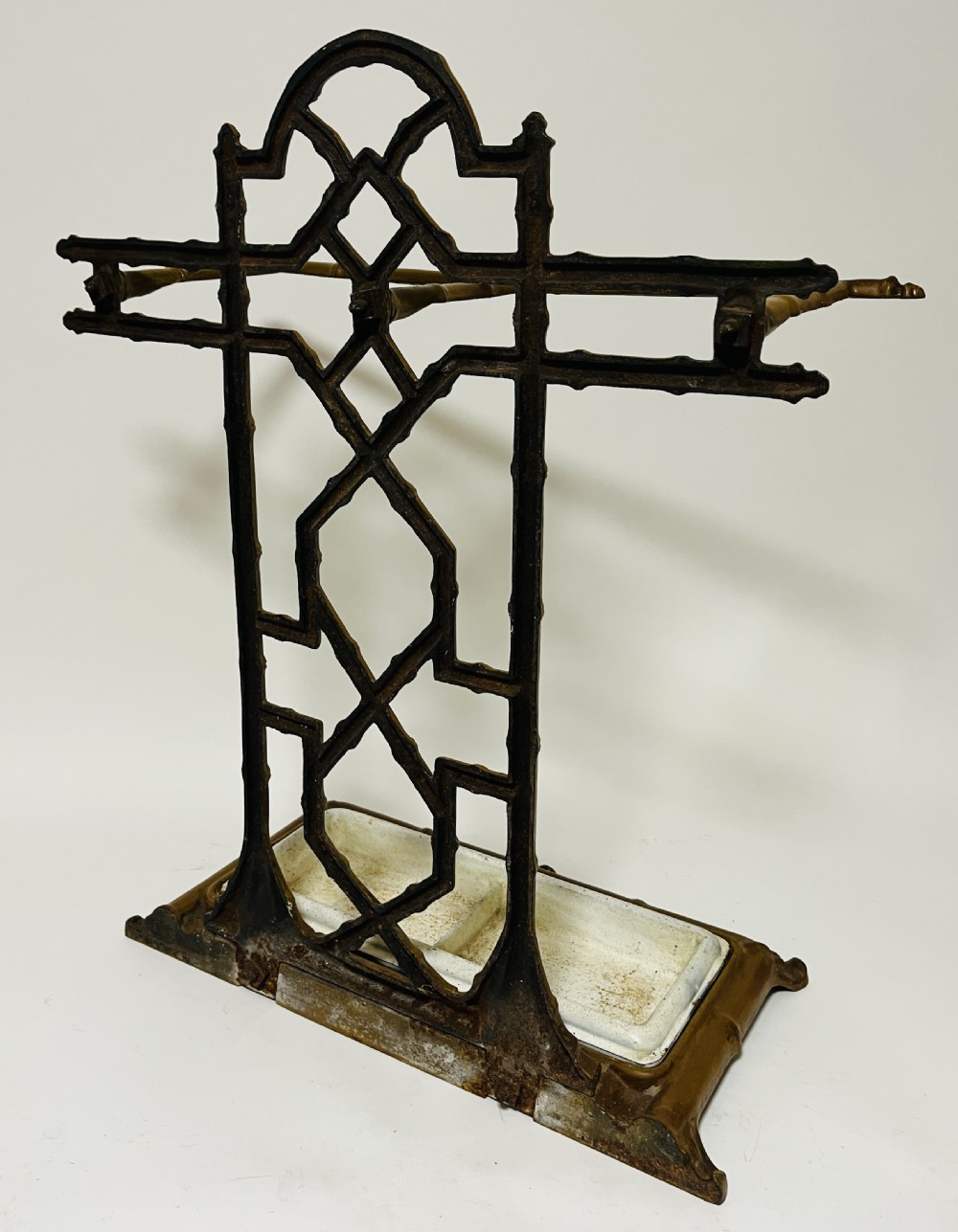 A Victorian cast iron faux bamboo umbrella stand in brown paint featuring geometric lattice backwork and a removable two-compartment drip tray. View XII