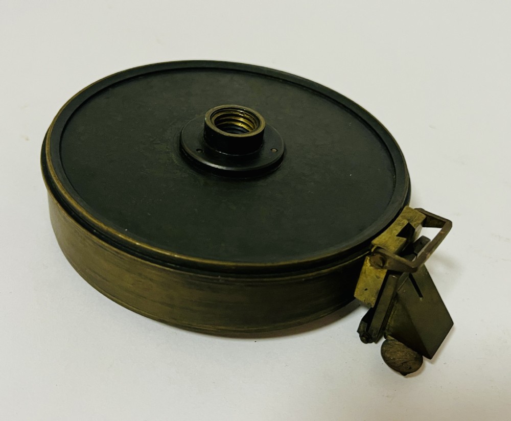 An antique brass surveying compass featuring folding sight vanes, a central needle, and a glass-covered dial. View XI